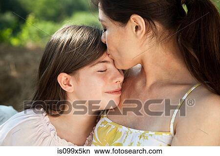Portrait of mother kissing daughter on forehead View Large Photo Image Picture - Portrait of mother kissing daughter on forehead. Fotosearch
