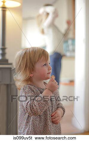 Stock Photograph - Portrait of toddler eating snack. Fotosearch