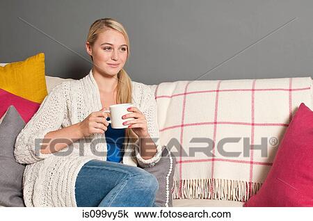 Portrait of woman on sofa holding cup View Large Photo Image Stock Image - Portrait of woman on sofa holding cup. Fotosearch