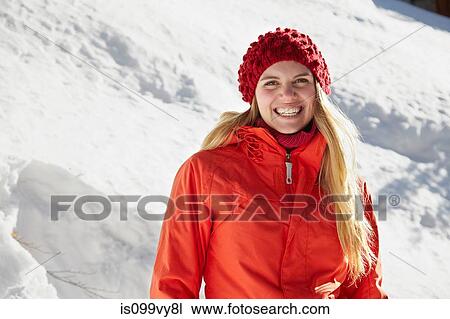 Stock Image - Portrait of woman wearing red knit hat and coat. Fotosearch