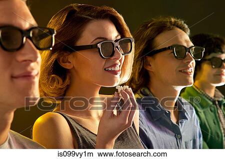 Row of people watching 3D movie, woman with popcorn View Large Photo Image Picture - Row of people watching 3D movie, woman with popcorn. Fotosearch