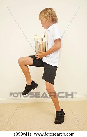 Stock Photograph - Schoolboy carrying stack of school books. Fotosearch