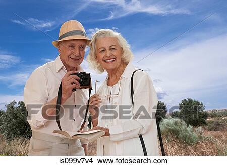Senior couple exploring landscape with camera View Large Photo Image Picture - Senior couple exploring landscape with camera. Fotosearch