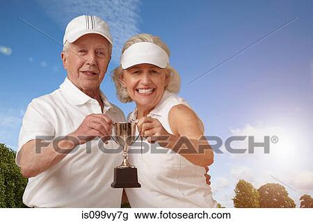 Senior couple holding tennis trophy View Large Photo Image Stock Image - Senior couple holding tennis trophy. Fotosearch