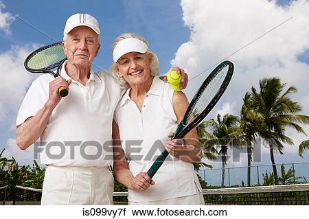 Stock Image - Senior couple ready for tennis. Fotosearch