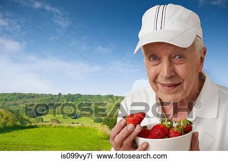 Senior man in tennis clothes with strawberries against rural scene View Large Photo Image Stock Image - Senior man in tennis clothes with strawberries against rural scene. Fotosearch