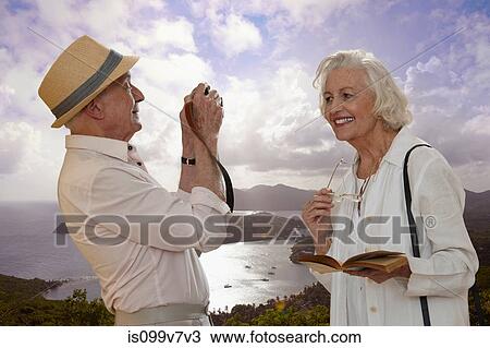 Senior man photographing wife by the sea View Large Photo Image Stock Image - Senior man photographing wife by the sea. Fotosearch
