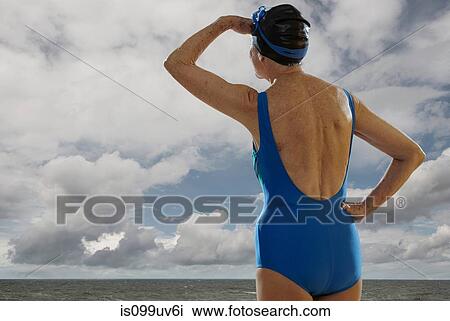 Senior woman wearing swimsuit looking towards sea, shielding eyes View Large Photo Image Stock Image - Senior woman wearing swimsuit looking towards sea, shielding eyes. Fotosearch
