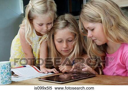 Three girls looking at digital tablet View Large Photo Image Stock Photography - Three girls looking at digital tablet. Fotosearch