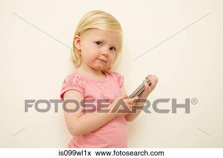 Toddler holding smartphone View Large Photo Image Stock Photo - Toddler holding smartphone. Fotosearch