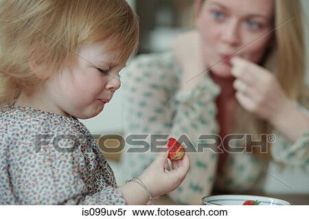 Toddler holding strawberry, pulling face View Large Photo Image Stock Photography - Toddler holding strawberry, pulling face. Fotosearch