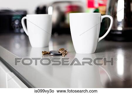 Two coffee mugs with keys on kitchen counter View Large Photo Image Picture - Two coffee mugs with keys on kitchen counter. Fotosearch