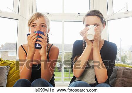 Two girls drinking hot drinks View Large Photo Image Stock Image - Two girls drinking hot drinks. Fotosearch