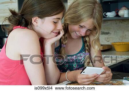 Two girls looking at smartphone View Large Photo Image Picture - Two girls looking at smartphone. Fotosearch