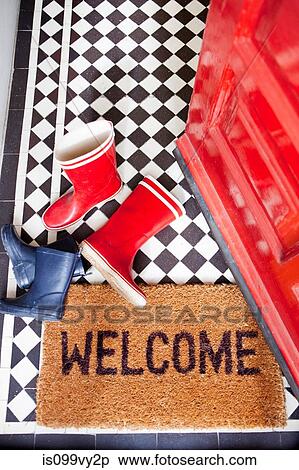 Stock Photography - Welcome mat and wellington boots. Fotosearch