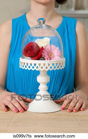 Stock Photograph - Woman and cake stand with flowers. Fotosearch