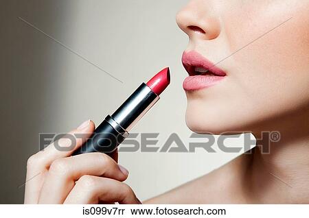 Stock Photography - Woman applying lipstick. Fotosearch