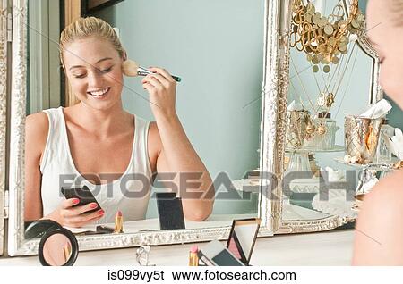 Stock Photograph - Woman applying make up. Fotosearch