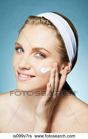 Stock Photograph - Woman applying moisturiser. Fotosearch