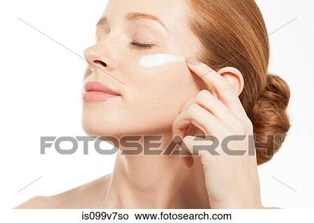 Woman applying moisturiser with eyes closed View Large Photo Image Picture - Woman applying moisturiser with eyes closed. Fotosearch