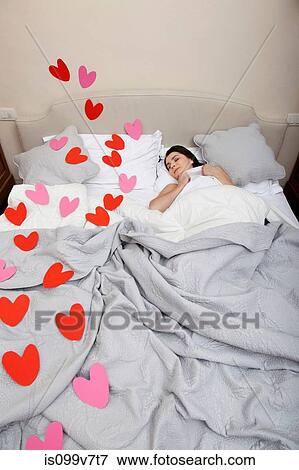 Woman asleep in bed with heart shapes on bedclothes View Large Photo Image Stock Photo - Woman asleep in bed with heart shapes on bedclothes. Fotosearch