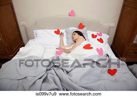 Woman asleep in bed with heart shapes on bedclothes View Large Photo Image Stock Photo - Woman asleep in bed with heart shapes on bedclothes. Fotosearch
