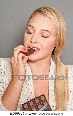 Woman biting chocolate View Large Photo Image Stock Photography - Woman biting chocolate. Fotosearch