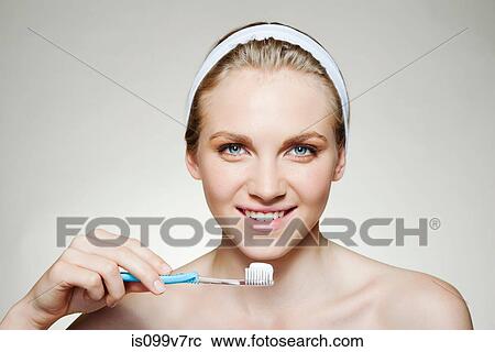 Stock Image - Woman brushing teeth. Fotosearch