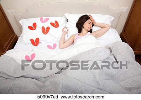 Woman crying in bed with broken heart shapes on bedclothes View Large Photo Image Stock Image - Woman crying in bed with broken heart shapes on bedclothes. Fotosearch