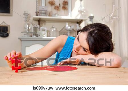 Stock Photo - Woman doing heart shaped jigsaw puzzle. Fotosearch