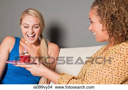 Woman giving friend cupcake View Large Photo Image Picture - Woman giving friend cupcake. Fotosearch