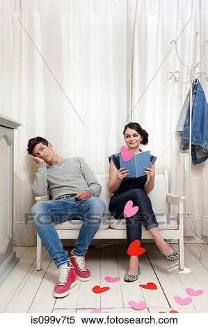 Woman holding book with bored man and heart shapes View Large Photo Image Stock Photography - Woman holding book with bored man and heart shapes. Fotosearch