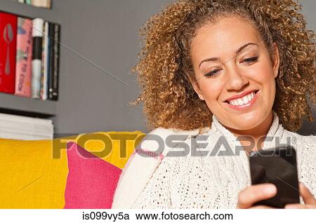 Stock Image - Woman holding cell phone. Fotosearch