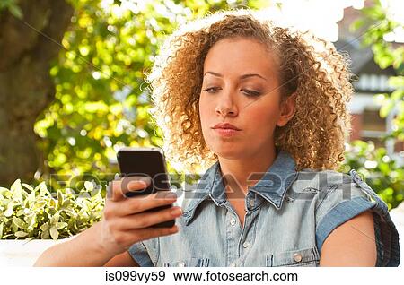 Stock Photo - Woman holding cell phone. Fotosearch