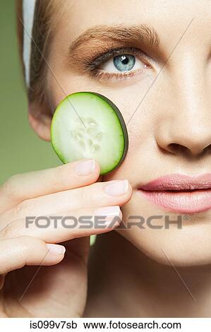 Woman holding slice of cucumber View Large Photo Image Stock Image - Woman holding slice of cucumber. Fotosearch
