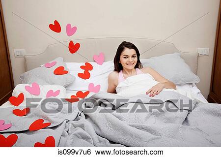 Woman in bed with heart shapes on bedclothes View Large Photo Image Stock Photograph - Woman in bed with heart shapes on bedclothes. Fotosearch