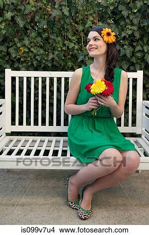 Woman on bench holding flowers View Large Photo Image Picture - Woman on bench holding flowers. Fotosearch
