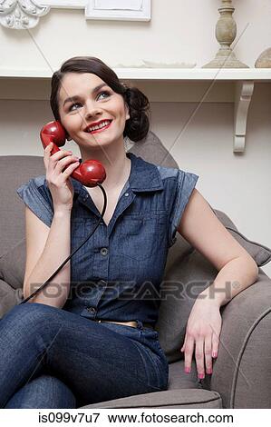 Stock Photo - Woman on sofa on the phone. Fotosearch