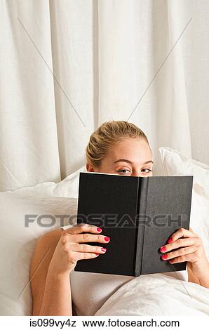 Woman reading book in bed View Large Photo Image Stock Photo - Woman reading book in bed. Fotosearch