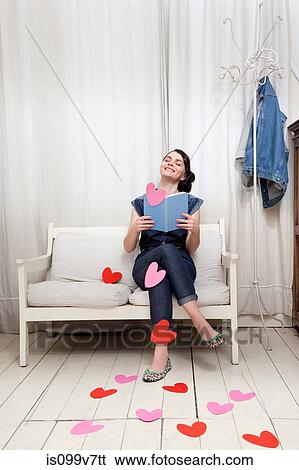 Stock Photograph - Woman reading book with heart shapes. Fotosearch