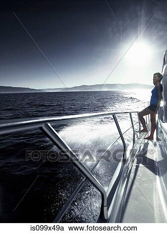 Woman standing alone on deck of yacht View Large Photo Image Stock Image - Woman standing alone on deck of yacht. Fotosearch
