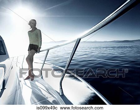 Stock Image - Woman standing on deck of yacht. Fotosearch