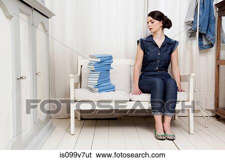Stock Photograph - Woman staring at stack of books. Fotosearch