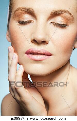 Stock Image - Woman touching face. Fotosearch