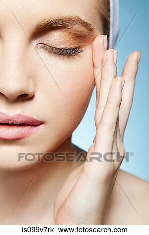 Stock Image - Woman touching face. Fotosearch