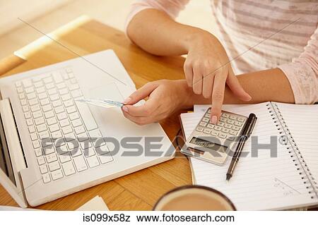 Woman using calculator with laptop View Large Photo Image Stock Photo - Woman using calculator with laptop. Fotosearch