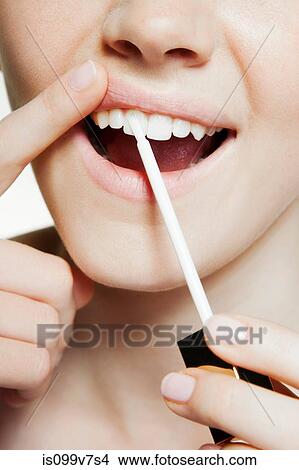 Woman using tooth whitening brush View Large Photo Image Picture - Woman using tooth whitening brush. Fotosearch