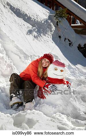 Woman with arms around snowman View Large Photo Image Stock Photograph - Woman with arms around snowman. Fotosearch