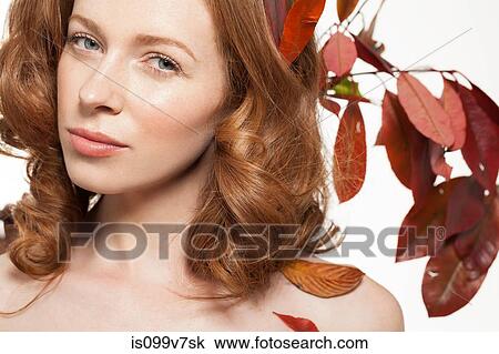 Stock Image - Woman with autumn leaves in her hair. Fotosearch