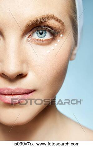 Stock Photo - Woman with eye cream around eye. Fotosearch